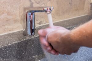 man washing hands and water saving in washroom